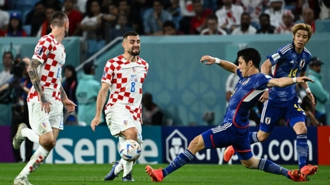 Gelandang Jepang Wataru Endo (Kanan) berebut bola dengan gelandang Kroasia Mateo Kovacic dan gelandang Jepang Takefusa Kubo pada pertandingan babak 16 besar Piala Dunia Qatar 2022 antara Jepang dan Kroasia di Al-Janoub Stadion di Al-Wakrah, selatan Doha pada 5 Desember 2022 (sumber: suara.com)