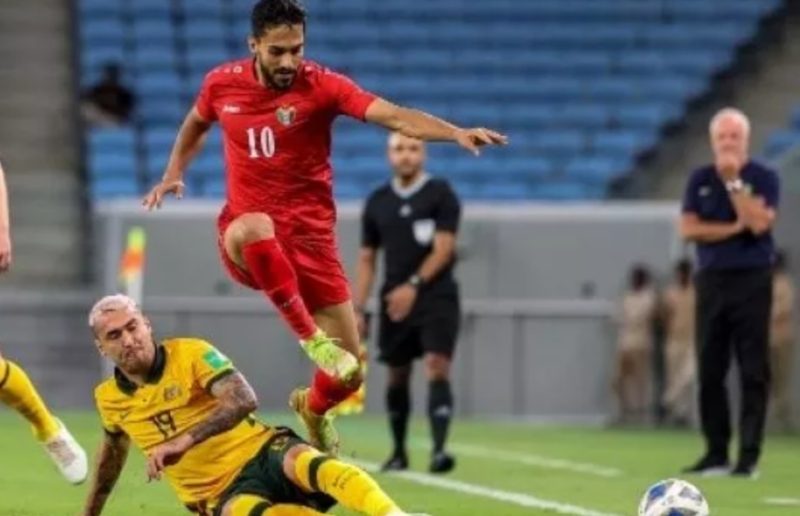 Pemain depan Yordania Musa Al-Taamari (Atas) melewati hadangan gelandang Australia Gianni Stensness (Bawah) pada pertandingan persahabatan antara Australia dan Yordania di Stadion al-Janoub di ibukota Qatar, Doha, pada 1 Juni 2022. KARIM JAAFAR/AFP