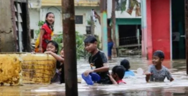 ILUSTRASI Banjir atau bancana hidrometrologi- Sejumlah anak bermain saat banjir di kawasan pemukiman penduduk, Rawajati, Jakarta Selatan, Senin (27/2/2023). [Suara.com/Alfian Winanto]