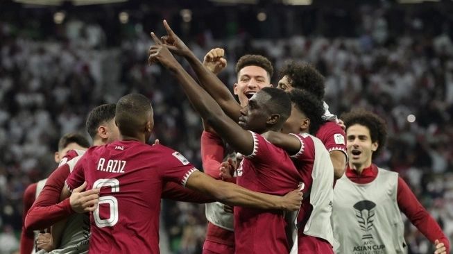Penyerang Qatar Almoez Ali (tengah) merayakan bersama rekan satu timnya setelah mencetak gol ketiga timnya pada pertandingan sepak bola semifinal Piala Asia AFC Qatar 2023 antara Iran dan Qatar di Stadion al-Thumama di Doha pada 7 Februari 2024. (Sumber: suara.com)