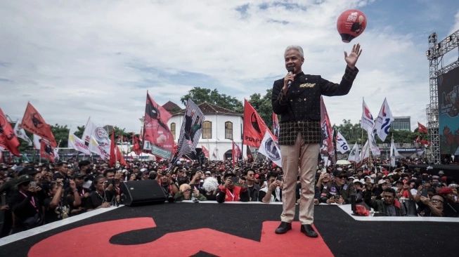 Capres nomor urut 3 Ganjar Pranowo (kiri) menyapa pendukungnya saat kampanye akbar capres-cawapres nomor urut 3 di Solo, Jawa Tengah, Sabtu (10/2/2024) (sumber: suara.com)