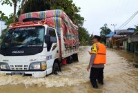 Sebuah Truck membawa sembako saat melintas di kawasan banjir di Desa Kandui, Senin (26/02/2024).Foto.Ade.1tulah.com