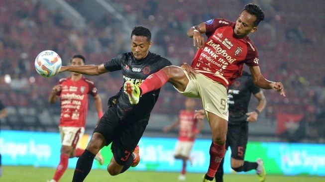 Pesepak bola Bali United Rahmat (kanan) berebut bola dengan pesepak bola Persis Solo Arif Budiyono (kiri) saat pertandingan Liga 1 2023/2024 di Stadion Kapten I Wayan Dipta, Gianyar, Bali, Kamis (29/2/2024). Bali United berhasil mengalahkan Persis Solo dengan skor 3-2 (sumber: suara.com)