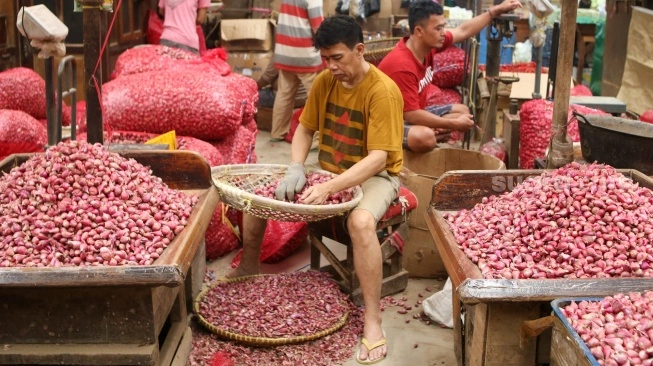 Pedagang menata barang dagangannya di Pasar Induk Kramat Jati, Jakarta, Senin (29/1/2024) (sumber: suara.com)