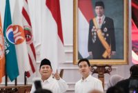 Presiden terpilih Indonesia Prabowo Subianto (kiri) dan Wakil Presiden terpilih Gibran Rakabuming Raka (kanan) di depan potret Presiden Indonesia Joko Widodo usai rapat pleno KPU di Jakarta, 24 April 2024. (Yasuyoshi CHIBA / AFP)