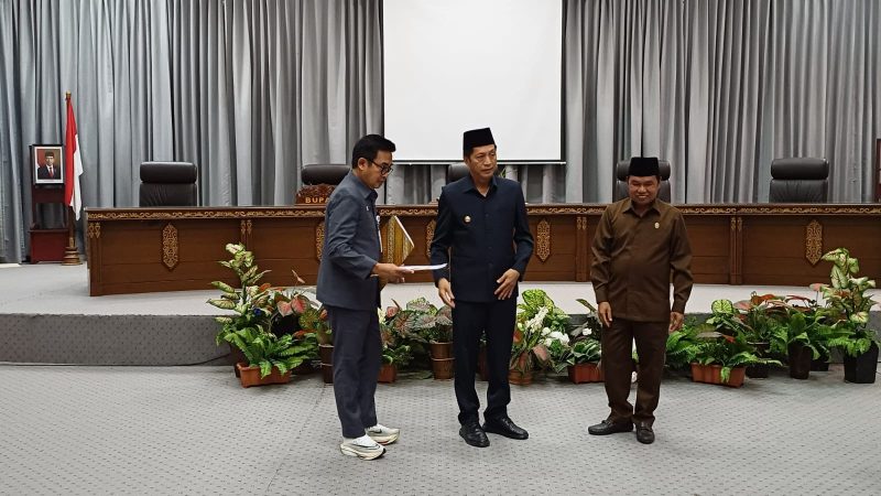 Pj Bupati Drs Muhlis saat menyerahkan pidato penyampaian Raperda pengelolaan sampah, Senin (29/04/2024).Foto.Delia/1tulah.com