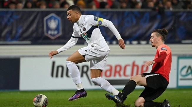 Penyerang Paris Saint-Germain(PSG), Kylian Mbappe (kiri) menggiring bola saat ditempel ketat penyerang Revel, Pierre Ritter selama pertandingan babak 64 besar Piala Prancis 2023-2024 antara US Revel vs Paris Saint-Germain di stadion Pierre-Fabre di Castres, Prancis selatan, pada 7 Januari 2024.  (sumber: suara.com)