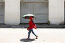 Seorang perempuan menggunakan payung untuk berlindung dari terik matahari saat cuaca panas di Manila pada 28 April 2024. (Foto: AFP)