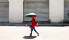 Seorang perempuan menggunakan payung untuk berlindung dari terik matahari saat cuaca panas di Manila pada 28 April 2024. (Foto: AFP)