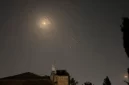 Tangkapan layar dari video AFPTV ini menunjukkan ledakan dan jejak-jejak rudal menerangi langit Yerusalem selama serangan Iran terhadap Israel, Minggu (14/4/2024) (sumber: suara.com)
