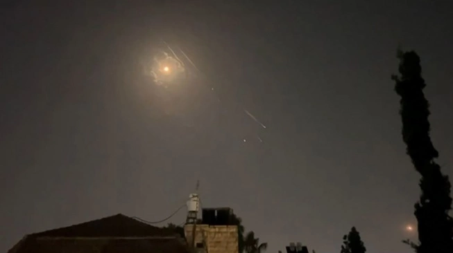 Tangkapan layar dari video AFPTV ini menunjukkan ledakan dan jejak-jejak rudal menerangi langit Yerusalem selama serangan Iran terhadap Israel, Minggu (14/4/2024) (sumber: suara.com)