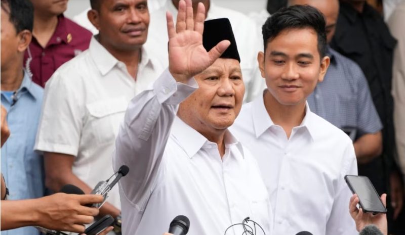 Menteri Pertahanan Indonesia dan presiden terpilih Prabowo Subianto (kiri tengah), melambaikan tangannya didampingi pasangannya, Gibran Rakabuming Raka (kanan tengah), di Gedung Komisi Pemilihan Umum di Jakarta, Rabu, 24 April 2024. (AP/Achmad Ibrahim)