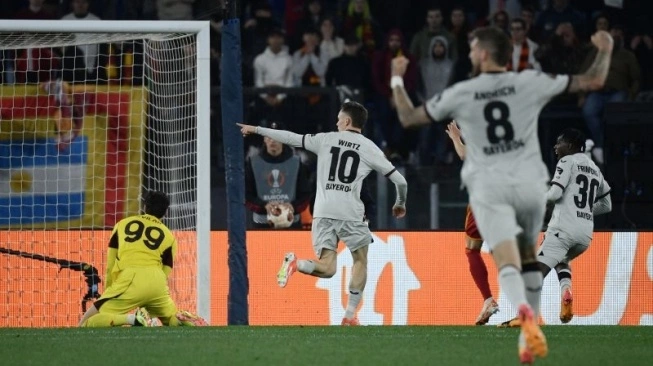 Gelandang Bayer Leverkusen Florian Wirtz mencetak gol ke dalam gawang kiper Roma Mile Svilar dalam leg pertama semifinal Liga Europa antara AS Roma dan Bayer Leverkusen di Stadion Olimpiade, Roma, pada 2 Mei 2024. (sumber: suara.com)