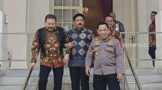 Menko Polhukam Hadi Tjahjanto menggandeng Kapolri Listyo Sigit Prabowo dan Jaksa Agung ST Burhanuddin di Istana Negara, Jakarta, Senin (27/5/2024). (sumber: suara.com)
