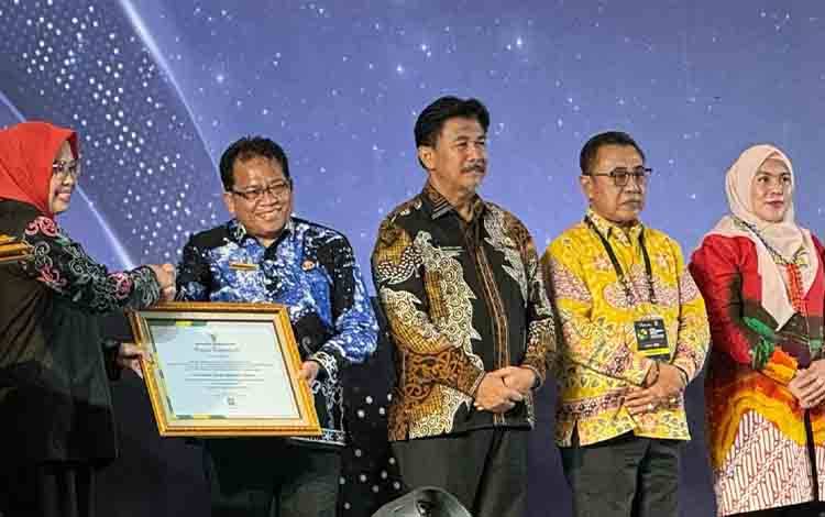 Pj Bupati Kapuas, Erlin Hardi menerima piagam penghargaan dari ANRI yang diserahkan oleh Deputi Bidang Pembinaan Kearsipan ANRI, Desi Pratiwi di hotel Mercure, Samarinda, Kalimantan Timur, Rabu (29/5/2024). Foto: Pemkab Kapuas