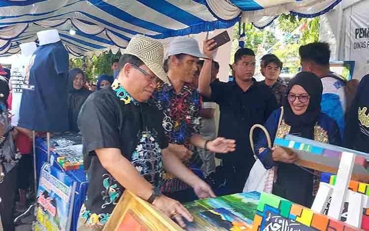 Pj Bupati Kapuas, Erlin Hardi saat kunjungi lapak Pameran UMKM, bertempat di halaman kantor Disdagperinkop dan UKM Kapuas pada Jumat (14/6/2024). Foto: Borneonews.co.id