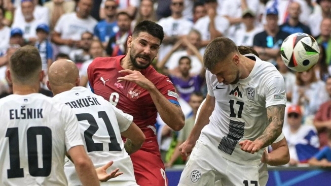 Penyerang timnas Serbia, Aleksandar Mitrovic dan penyerang Slovenia, Jan Mlakar berebut bola pada pertandingan kedua Grup C Euro 2024 antara Slovenia vs Serbia. Sumber foto : suara.com