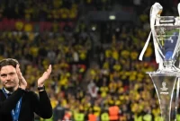 Pelatih Dortmund Edin Terzic bertepuk tangan dengan medali peraknya di samping trofi di akhir pertandingan sepak bola final Liga Champions 2023/2024 antara Real Madrid melawan Borussia Dortmund di Stadion Wembley, London, Inggris, Sabtu (1/6/2024). Sumber foto : suara.com
