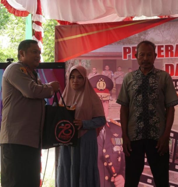 Kapolres Barito Utara, AKBP Gede Eka Yudharma saat menyerahkan paket sembako kepada warga. Selasa (25/6/2024). Foto. M Gazali
