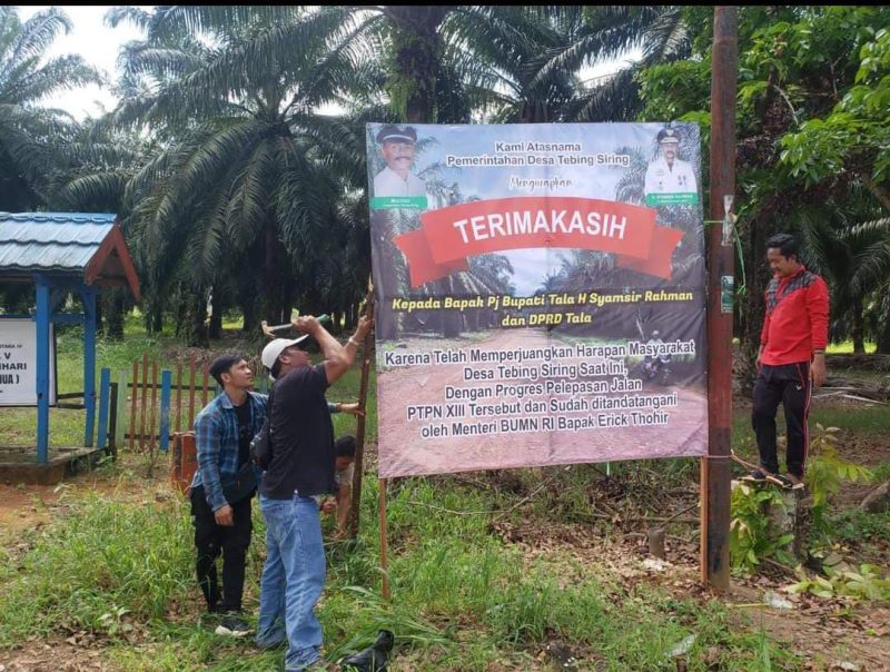 Pemasangan spanduk ucapan terima kasih kepada Pj Bupati Syamsir dan DPRD Tala dari warga Desa Tebing Siring. Foto: Warga Tebing Siring