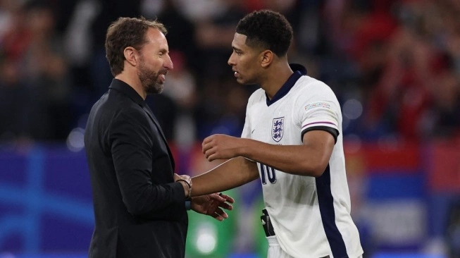 Pelatih kepala Inggris Gareth Southgate merayakan bersama gelandang Inggris Jude Bellingham di akhir pertandingan sepak bola Grup C UEFA Euro 2024 (sumber: suara.com)
