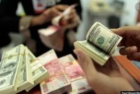 Seorang pegawai valas menghitung uang kertas dollar AS dan rupiah, di Makassar, Sulawesi Selatan, 31 Januari 2013. (Foto: Yusuf Ahmad/Reuters)