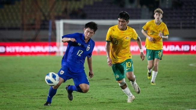 Pesepak bola Timnas Thailand Sorakrit Kaewsri (kiri) berebut bola dengan pesepak bola Timnas Australia Nickolas Gustavo Alfaro (kanan) pada pertandingan Final Piala AFF U-16 di Stadion Manahan, Solo, Jawa Tengah, Rabu (3/7/2024). Sumber foto : suara.com