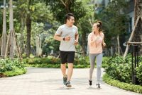 Vietnamese man and woman jogging together in the park