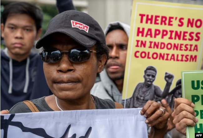 Para aktivis membawa poster-poster saat berdemo untuk menarik perhatian kepada isu HAM Papua, di depan Kedutaan Besar Belanda di Jakarta, di tengah kunjungan Raja Belanda Willem-Alexander, 12 Maret 2020. (Foto: AFP)
