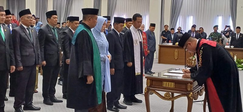 Ketua PN Muara Teweh, Sugiannur SH menandatangi dokumen pelantikan, usai memimpin sumpah janji 25 anggota DPRD Barut, Senin (19/8/2024). Foto.Delia/1tulah.com