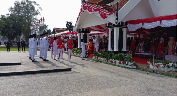 Pj Bupati Barsel, H. Deddy Winarwan saat menyerahkan bendera merah putih pada upacara peringatan HUT Kemerdekaan RI ke-79 tahun 2024, yang berlangsung di halaman kantor Bupati setempat, Sabtu (17/8/2024). Foto. Alifansyah/1tulah.com