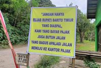 Baliho yang dipasang warga persis di pojok belakang pagar Rumah Jabatan Bupati Barito Timur. Foto : 1tulah.com/zakirin