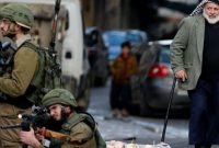 
Seorang pria Palestina melihat tentara Israel membidikkan senjata ke arah pengunjuk rasa (sumber: suara.com) 