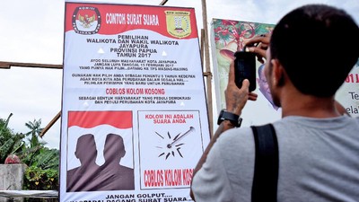 Ilustrasi - Warga mengabadikan baliho surat suara. Foto: Antara/Indrayadi TH