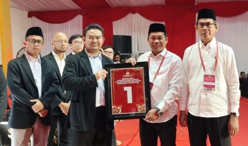 Calon bupati dan wakil bupati Balangan, Abdul Hadi-Akhmad Fauzi memperlihatkan Nomor Urut 1 hasil pengundian di KPU setempat pada Senin (23/9/2024) malam. Foto: Windi/1tulah.com