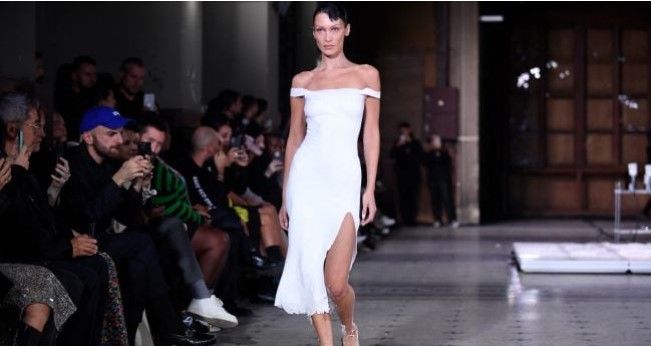 Model Bella Hadid tampil di catwalk dengan slip dress yang disemprot dengan kain Fabrican Spray-on selama peragaan busana Coperni Spring-Summer 2023 yang merupakan bagian dari Paris Fashion Week di Paris, Prancis, Jumat (30/9/2022). [JULIEN DE ROSA / AFP]