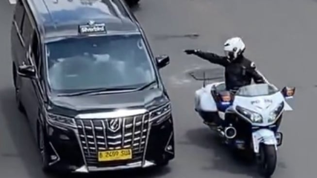 Aksi anggota Patwal tunjuk-tunjuk mobil Alphard saat kawal mobil dinas RI 36 di jalan raya. (sumber: suara.com)