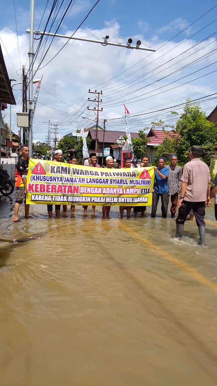 Puluhan warga Kelurahan Paliwara, Kecamatan Amuntai Tengah, HSU, Kalsel, khususnya Jemaah Langgar Syiarul Muslimin, melakukan aksi protes di tengah banjir, terkait adanya ETLE yang dianggap kurang pas penempatannya di dekat tempat ibadah. Foto: Warga Paliwara