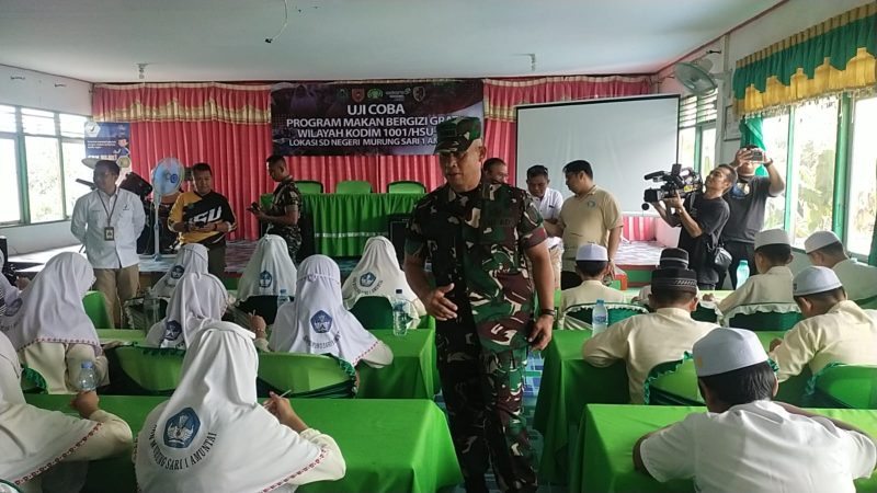 Kepala Staf Kodim 1001/HSU-BLG, Mayor Inf Andi Tiro, ketika menyapa siswa-siswi SDN Murung Sari 1 Amuntai, saat menyantap makanan menu Makan Bergizi Gratis. Foto: Windi/1tulah.com