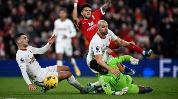Tendangan gelandang Manchester United #04 Sofyan Amrabat (2 kanan) diblok oleh gelandang Liverpool #07 Luis Diaz (tengah) dan kiper Manchester United asal Kamerun #24 Andre Onana selama pertandingan pekan ke-17 Liga Inggris antara Liverpool vs Manchester United di Anfield di Liverpool, barat laut Inggris pada 17 Desember 2023. Paul ELLIS / AFP.
