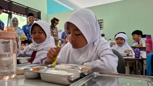 Seorang siswa menyantap menu makan bergizi gratis di sekolah yang ada di Gunungkidul, Senin (17/2/2025). (sumber: suara.com)