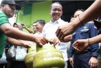 Menteri Energi dan Sumber Daya Mineral (ESDM) Bahlil Lahadalia (tengah) membantu melayani warga yang mengantre membeli gas elpiji 3 kilogram saat melakukan pemantauan di Karawaci, Tangerang, Banten, Selasa (4/1/2025). [ANTARA FOTO/Muhammad Iqbal/YU]