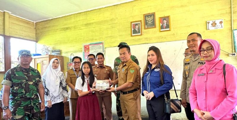 Asisten 1 Setda Bartim  Ari Panan P. Lelo (Memegang Makan Bergizi Gratis bersama anak sekolah). Foto : 1tulah.com/zakirin