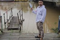 Tokoh pemuda kelahiran Amuntai ini, Junaidi, saat melakukan pengecekan debit air yang terus meningkat di Sungai Nagara, sekaligus mengambil sample air. Foto: Junaidi untuk 1tulah.com