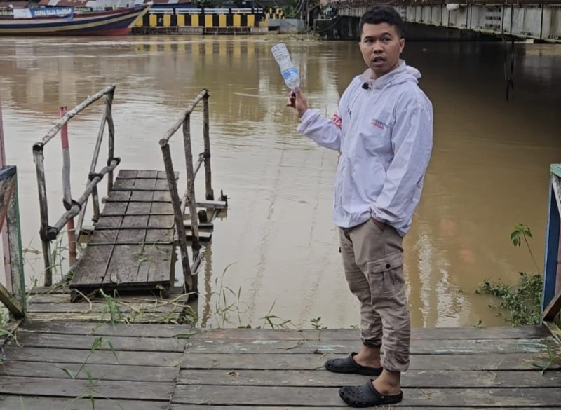 Tokoh pemuda kelahiran Amuntai ini, Junaidi, saat melakukan pengecekan debit air yang terus meningkat di Sungai Nagara, sekaligus mengambil sample air. Foto: Junaidi untuk 1tulah.com