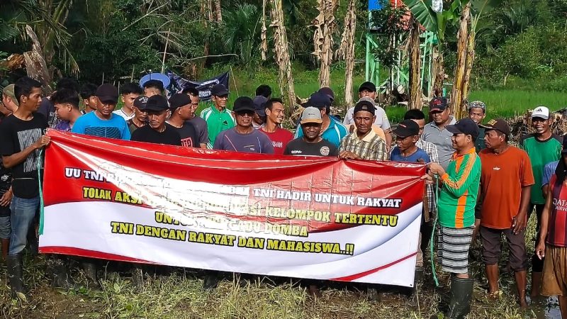 Puluhan warga, hingga pemuda, tak terkecuali tokoh masyarakat, di Kecamatan Sungai Pandan, Kabupaten HSU, Kalsel, saat membentangkan spanduk merah putih, sebagai wujud dukungan penuh atas Undang-Undang TNI. Foto: Windi/1tulah.com