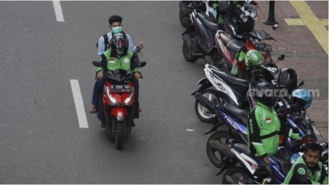 Sebagai ilustrasi PSBB Jakarta: Ojek online membawa penumpang melintas di kawasan Palmerah, Jakarta, Selasa (7/4). [Suara.com/Angga Budhiyanto]