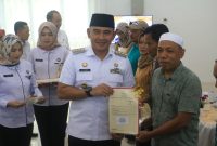 Bupati Tanah Laut (Tala), H Rahmat Trianto menyerahkan sebanyak 529 sertifikat bidang tanah melalui program Pendaftaran Tanah Sistematis Lengkap (PTSL) dari Kementerian Agraria dan Tata Ruang/Badan Pertanahan Nasional (ATR/BPN) di Aula Kantor Pertanahan (Kantah) Tala, Pelaihari, pada Rabu, 16 April 2025. Foto: MC Tala