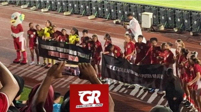 Seorang wanita yang mengenakan baju hitam menjadi sasaran hujat netizen usai secara paksa merebut spanduk demo Timnas Putri Indonesia. (IG garudarevolution.football)