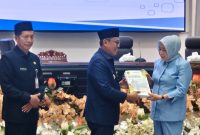 Pj Bupati Barito Utara, Indra Gunawan menyerahkan rancanan KUA dan PPAS kepada Ketua DPRD, Hj Mery Rukaini, Senin(21/7/25).Foto.Delia/1tulah.com